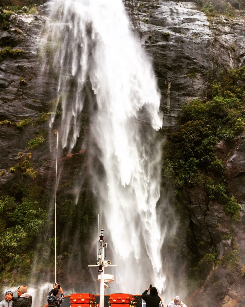 Boating under a waterfall, Milford Sound, Fiordland National Park, New Zealand