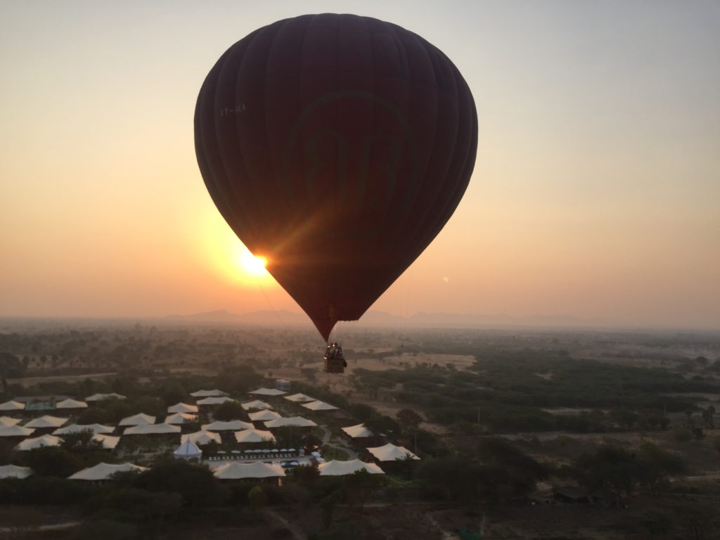 Sun rises beside the edge of a hot air balloon in Bagan, Myanmar