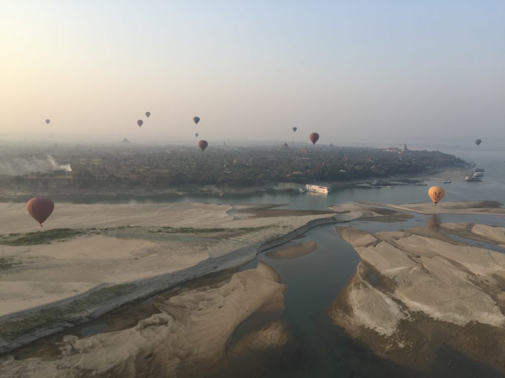 Hot air balloons landing on the sandy banks of the Irrawaddy River, Bagan, Myanmar
