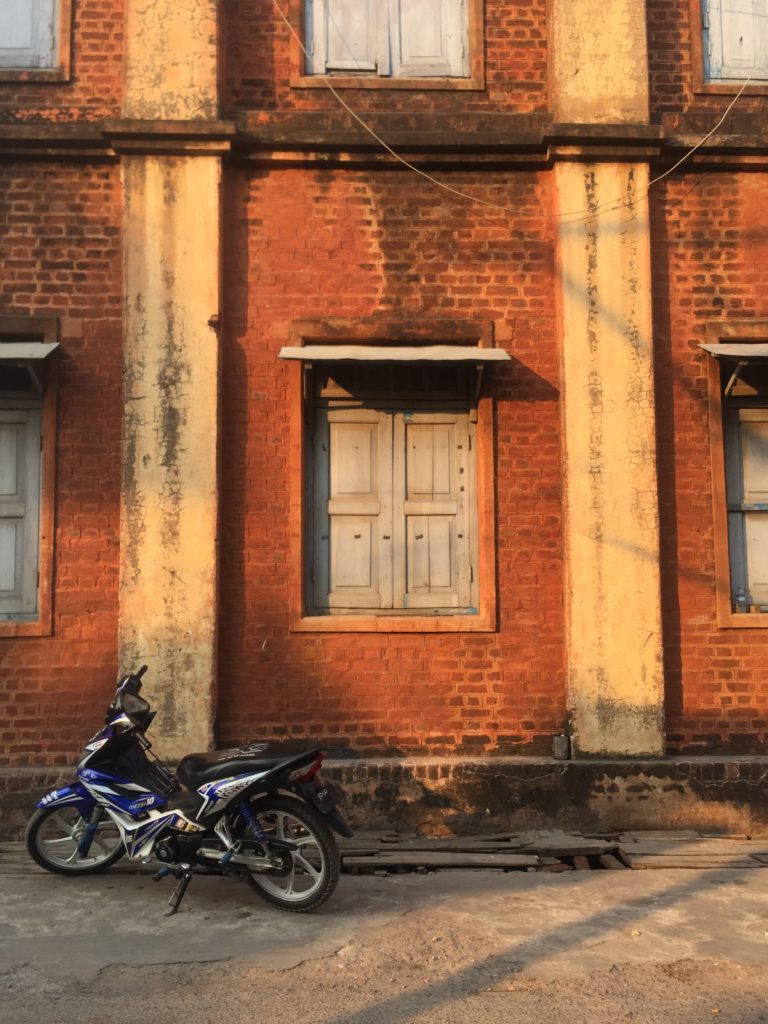 Motorbike parked in front of a brick building
