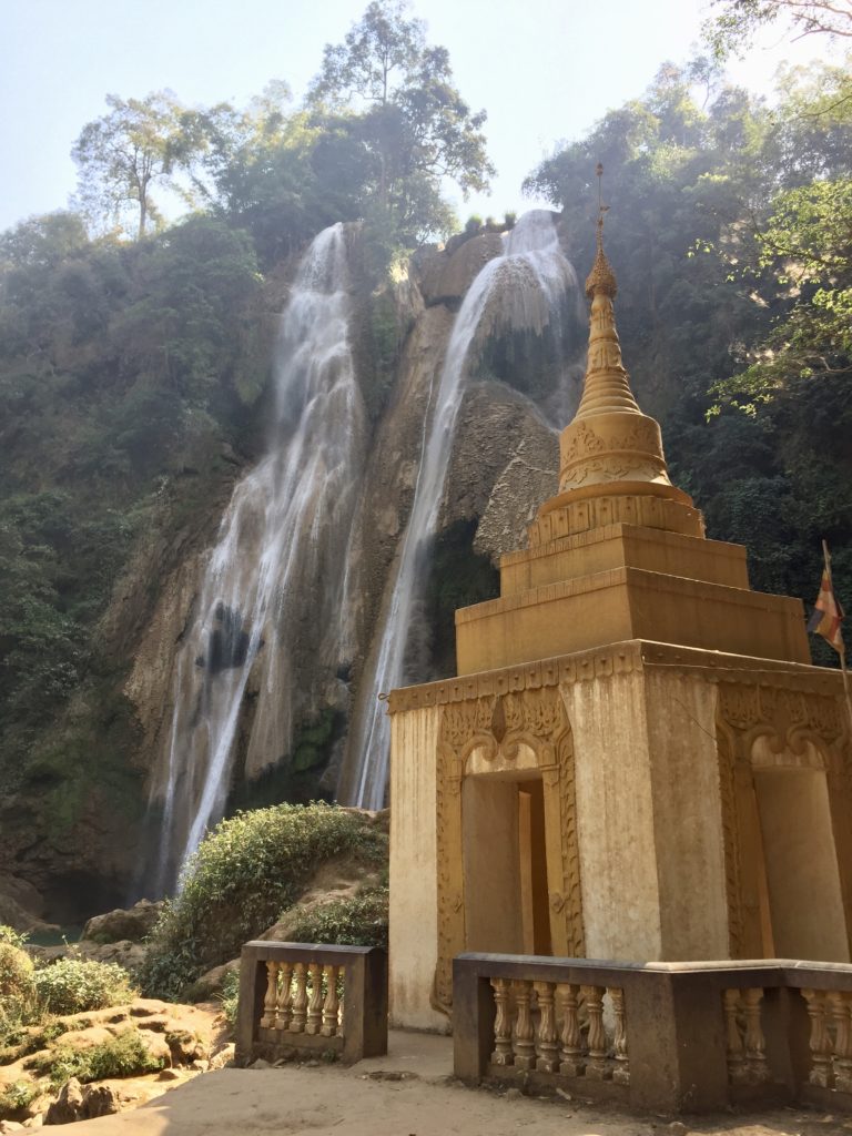 Small pagoda with waterfall flowing in the background