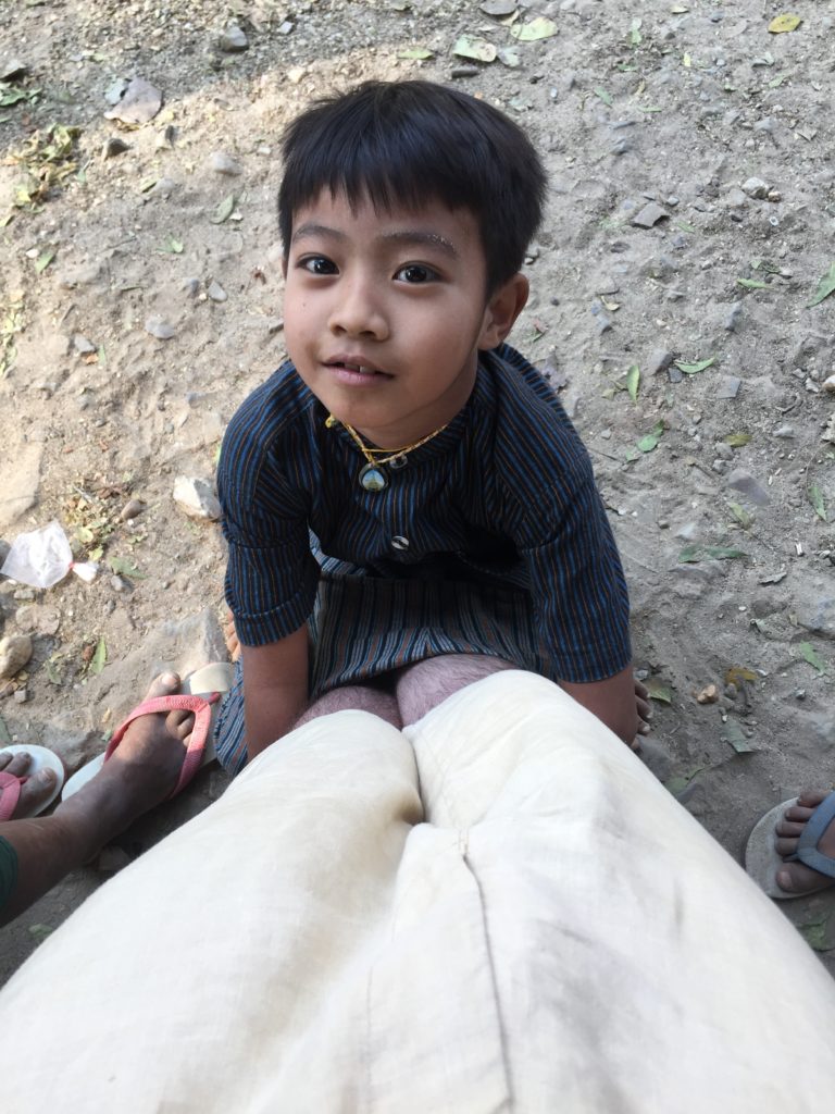 Young child looking up at me with his hands wrapped around my legs