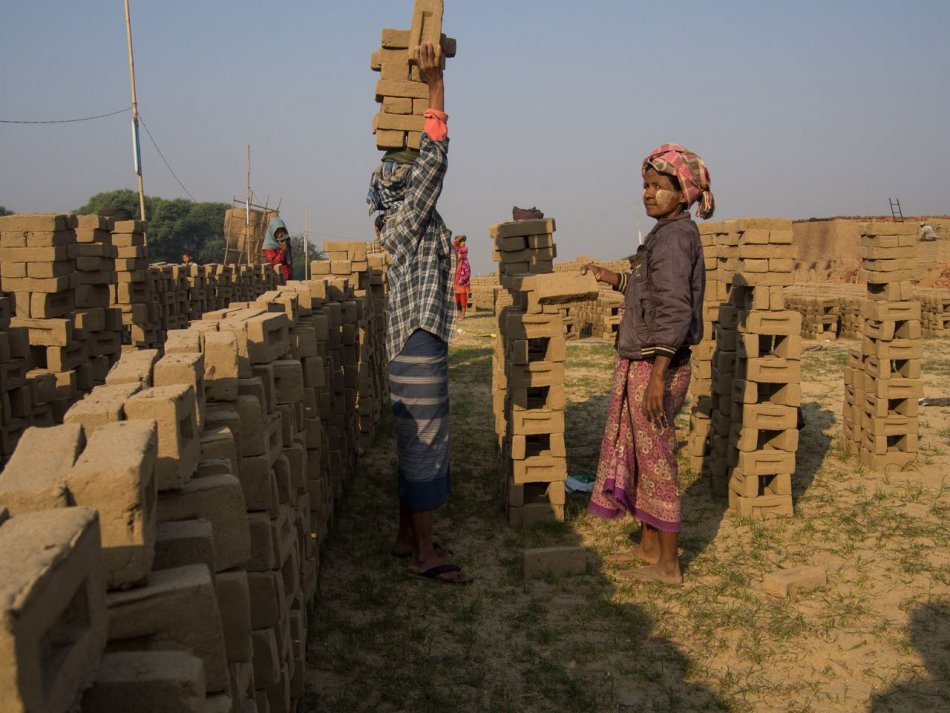 Workers carrying and stacking bricks