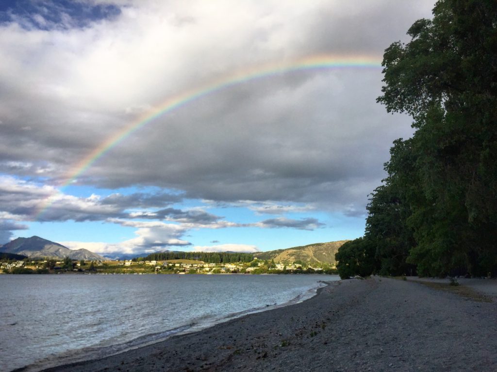 A rainbow curves over Lake Wanaka