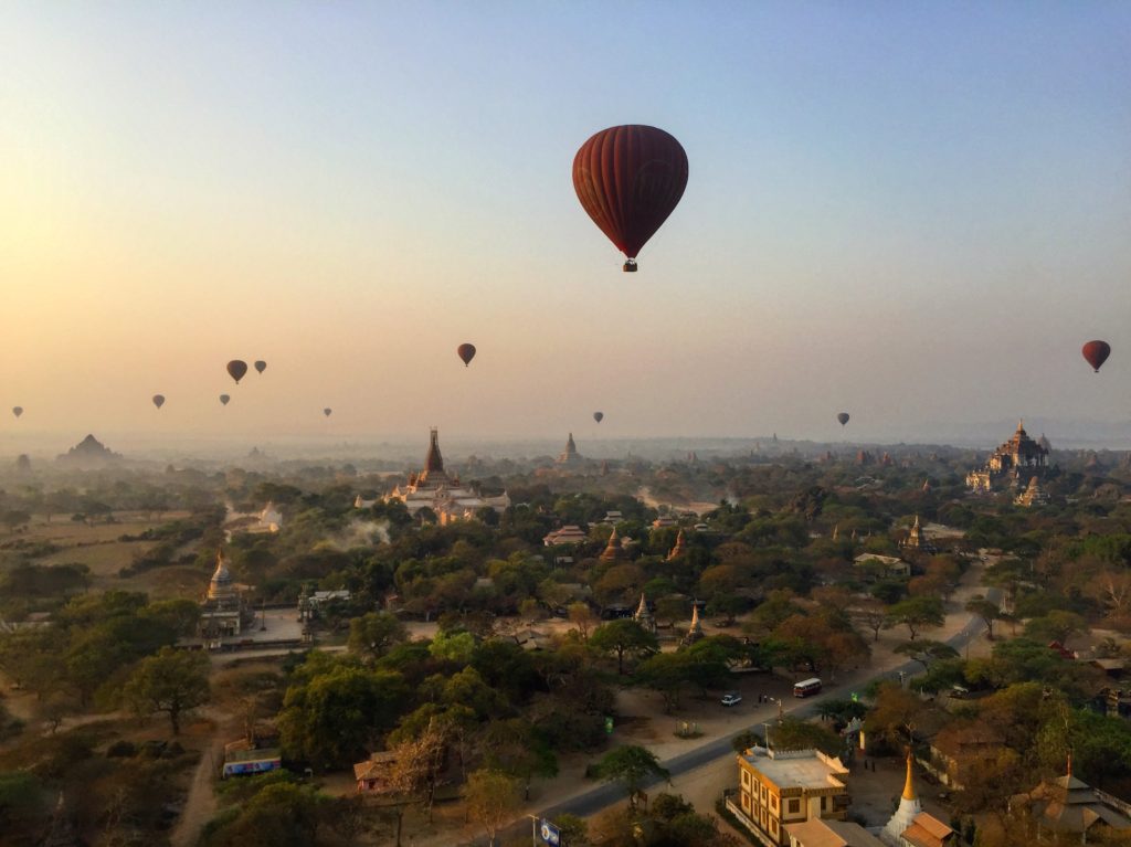 Eleven hot air balloons floating over the temples of Bagan spread out in the distance