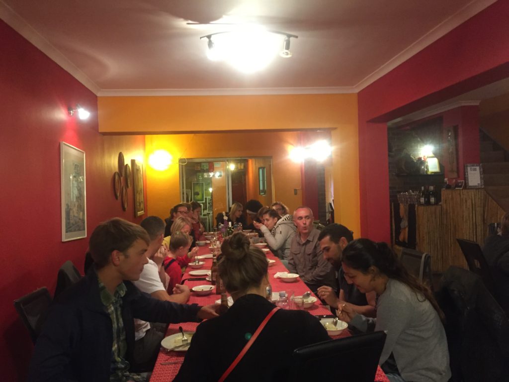 A large table of tourists eat dinner together