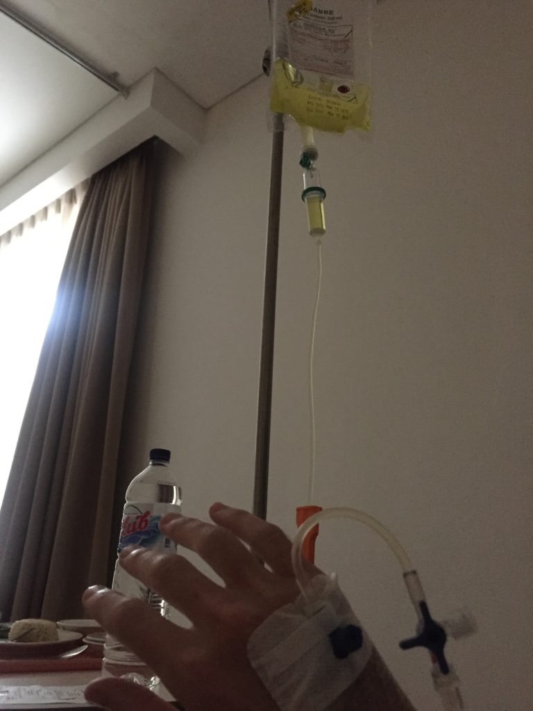 My arm, hooked up to an intravenous drip at Siloam Hospital Denpasar