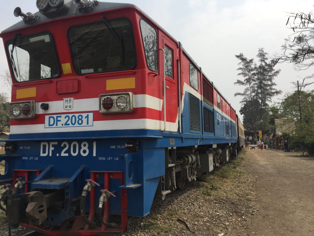 Photo of the red white and blue diesel engine at a stop in Shan State