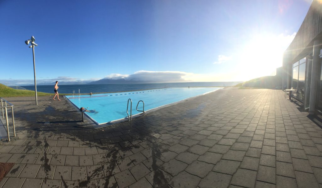 Panorama of the Hofsos swimming pool looking out onto a blue sky and deep blue water background of Skagafjordur and the Greenland Sea