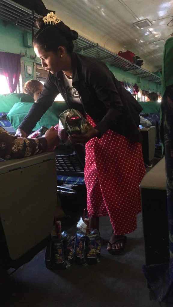 Vendor standing in aisle and selling her wares on the train