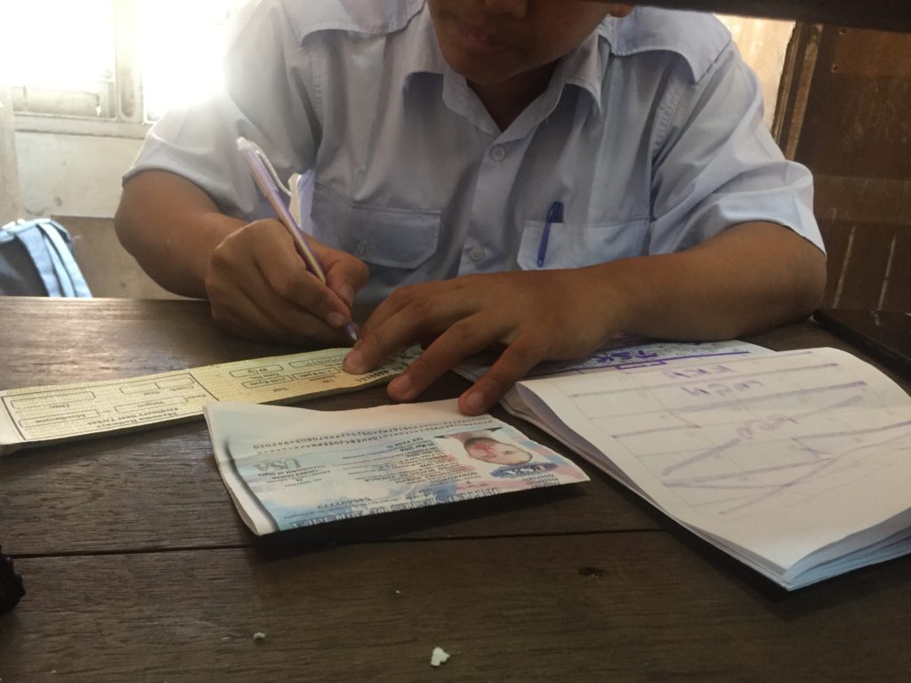 Staff write up a hand-written ticket at Myanmar Railways Advance Booking Office in Yangon