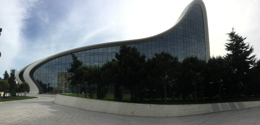 Side photo of the giant glass wall and sweeping curves of the Aliyev Center