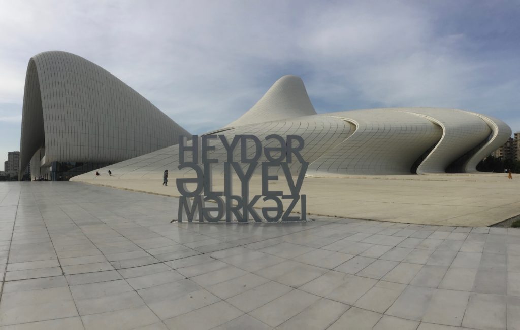 Curving all white Heydar Aliyev Center behind sign of same name