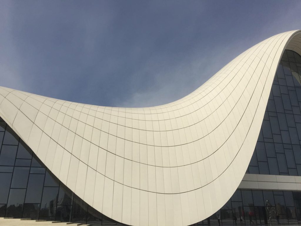 Curving white roof of the Heydar Aliyev Center with blue sky above