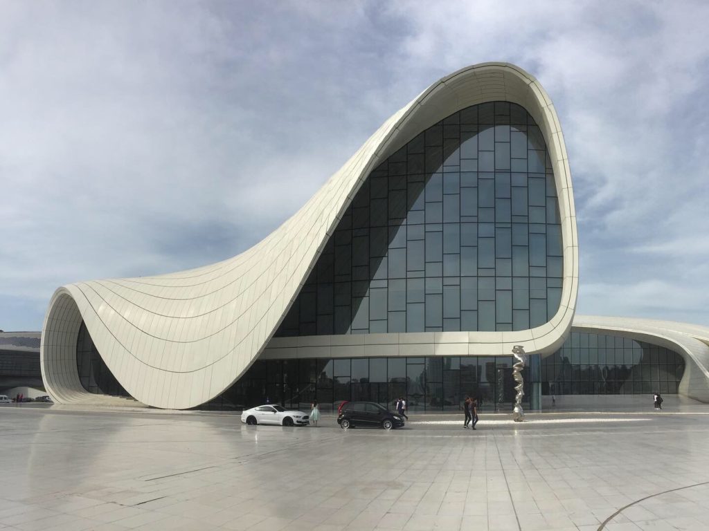 The entire Heydar Aliyev Center with sweeping white curves, reflective glass and sky background