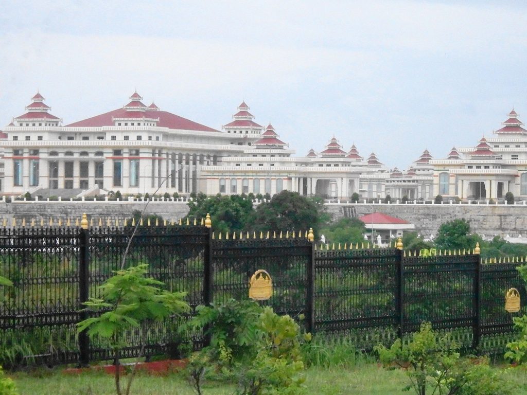 Myanmar's white and pink roofed Parliament complex seen behind a black fence