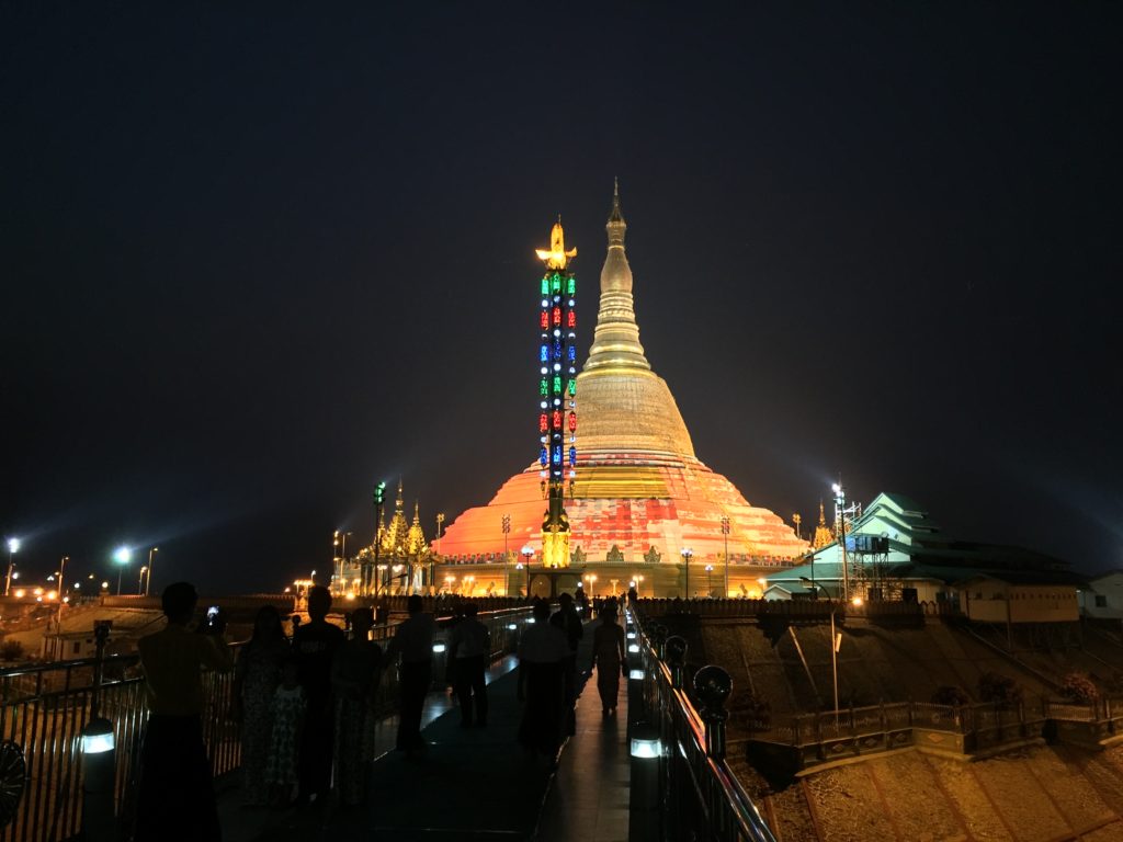 The orange and golden stupa of Uppatasanti Pagoda shines brightly at night