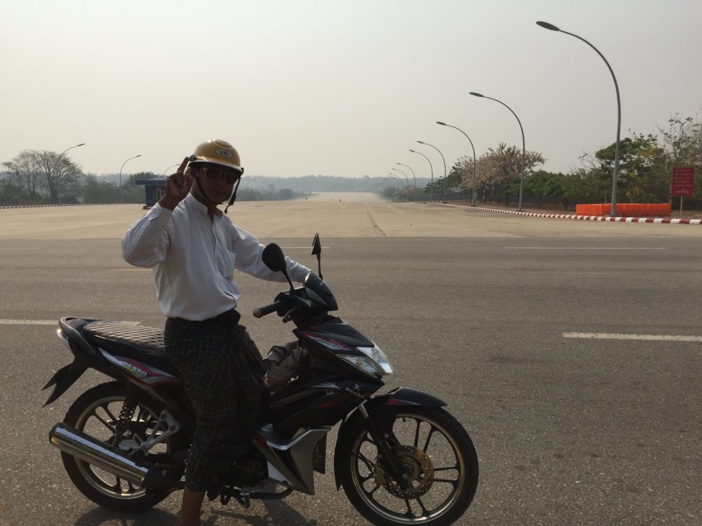 Burmese man sitting on his motorbike at the top of Naypyidaw's 20-lane concrete highway