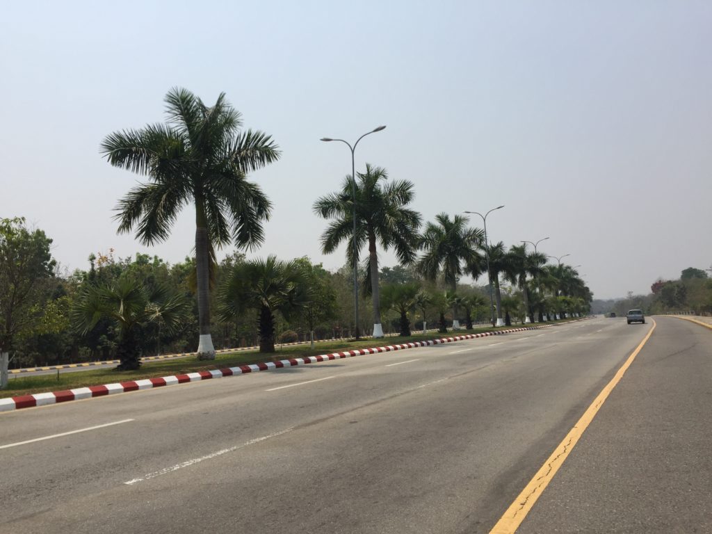 Wide boulevards, painted striped curbs and palm trees in the medians of Naypyidaw's typical road